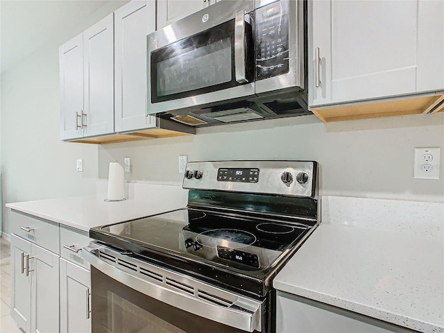 kitchen featuring stainless steel appliances and white cabinets