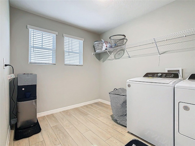 laundry room with independent washer and dryer and light wood-type flooring