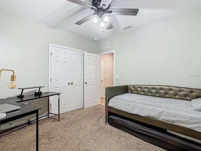 carpeted bedroom featuring ceiling fan and a closet