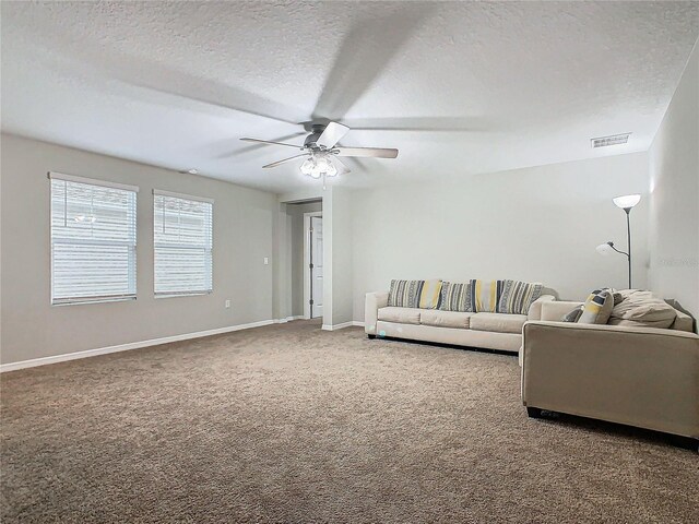 living room featuring ceiling fan, carpet floors, and a textured ceiling