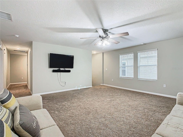 carpeted living room with ceiling fan and a textured ceiling