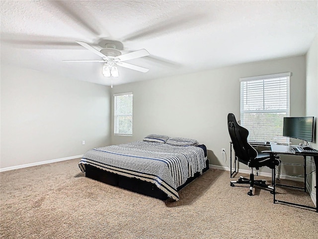 carpeted bedroom featuring multiple windows, a textured ceiling, and ceiling fan