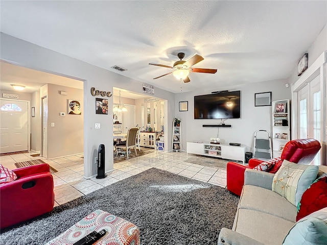 tiled living room with ceiling fan and a textured ceiling