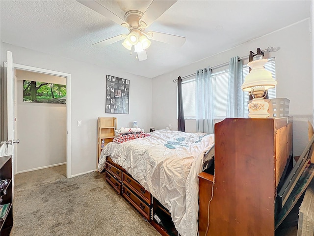 carpeted bedroom with ceiling fan and a textured ceiling