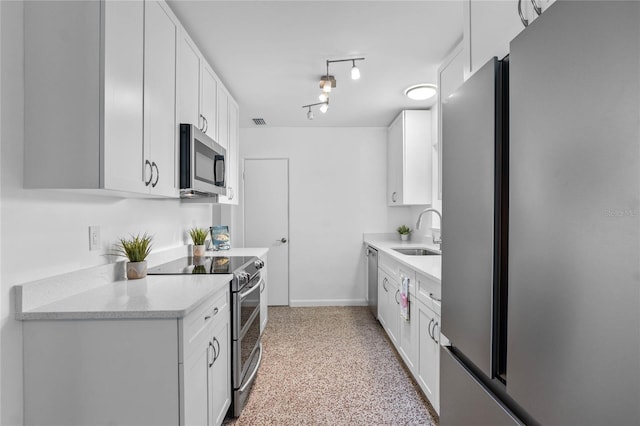 kitchen featuring stainless steel appliances, light stone countertops, sink, and white cabinets