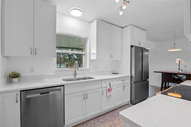 kitchen with white cabinetry, stainless steel appliances, sink, and pendant lighting