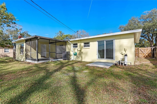 rear view of property with central AC unit, a yard, a patio area, and a sunroom