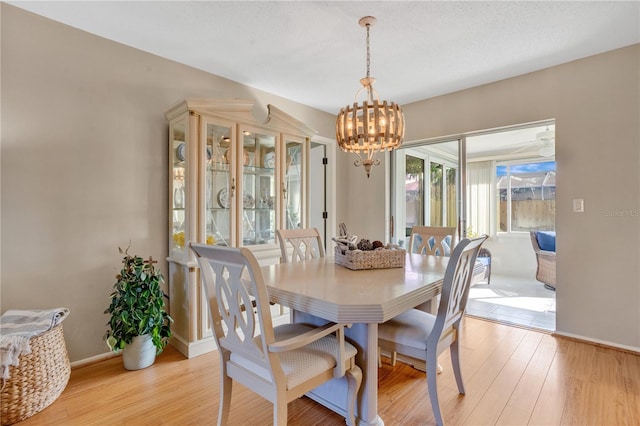 dining area featuring light wood-type flooring and a chandelier