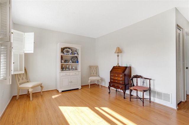 living area with built in shelves and light wood-type flooring