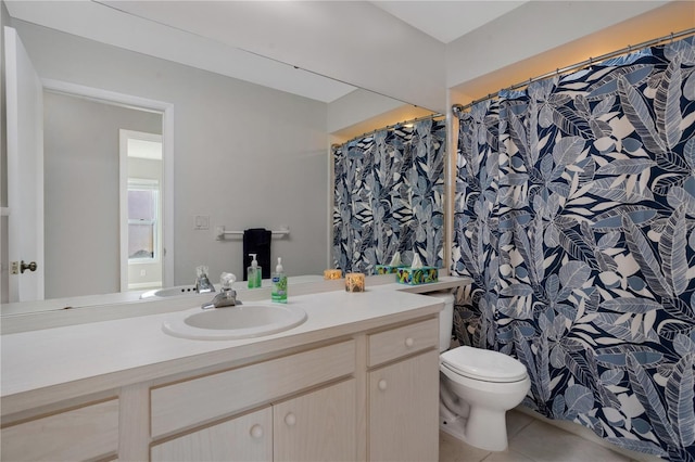 bathroom featuring toilet, vanity, and tile patterned flooring