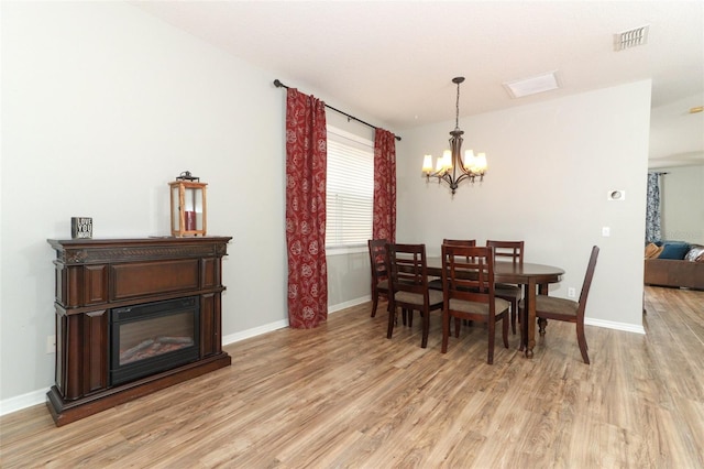 dining room with an inviting chandelier and light hardwood / wood-style flooring