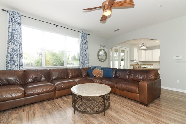 living room with ceiling fan, french doors, and light wood-type flooring