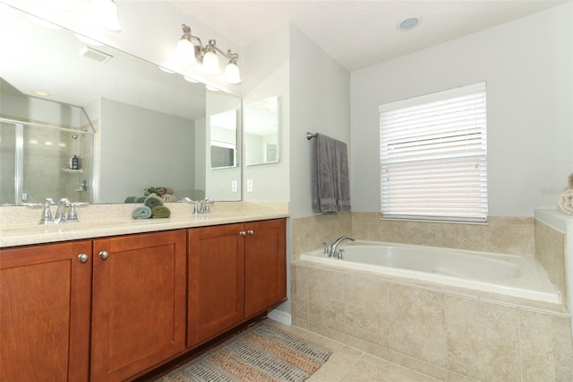 bathroom featuring vanity, tile patterned floors, plenty of natural light, and plus walk in shower