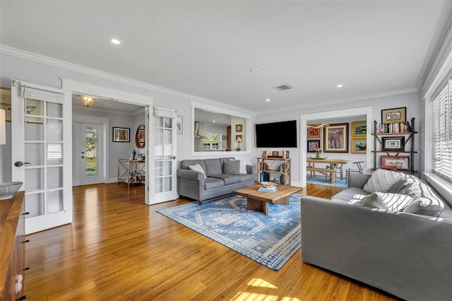 living room featuring ornamental molding, french doors, and wood-type flooring