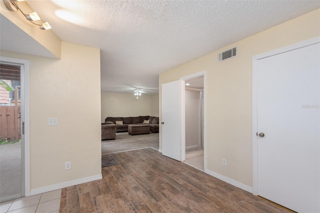 interior space with a textured ceiling and light hardwood / wood-style flooring