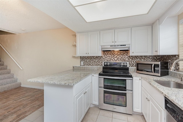 kitchen with white cabinets, kitchen peninsula, sink, and stainless steel appliances