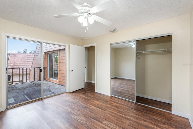 unfurnished bedroom featuring ceiling fan, a closet, dark hardwood / wood-style flooring, and a textured ceiling