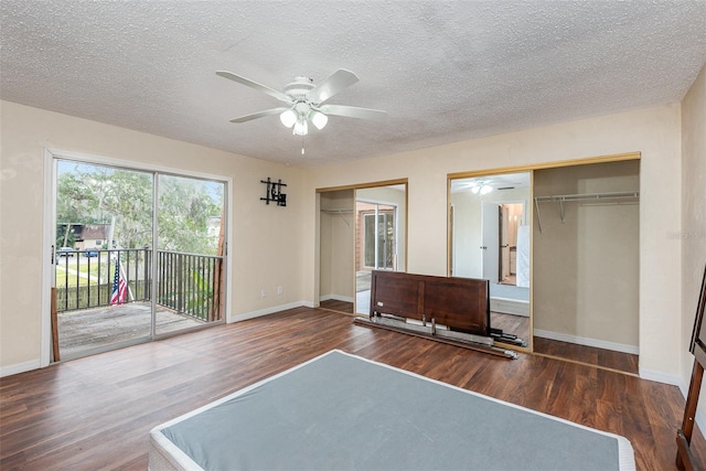 unfurnished bedroom with ceiling fan, multiple closets, access to outside, dark hardwood / wood-style flooring, and a textured ceiling