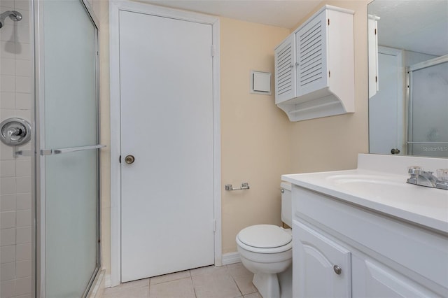 bathroom with toilet, vanity, a shower with door, and tile patterned floors