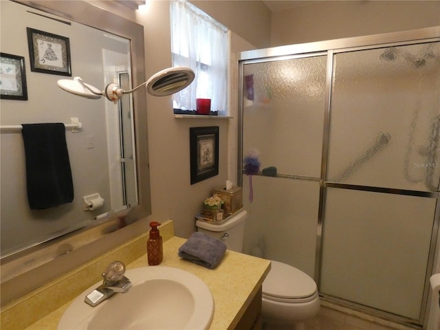 bathroom with a shower with door, vanity, and toilet