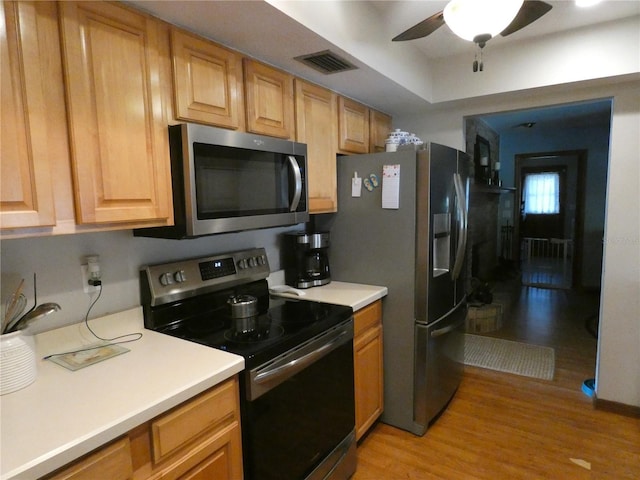 kitchen featuring stainless steel appliances, ceiling fan, and light hardwood / wood-style floors