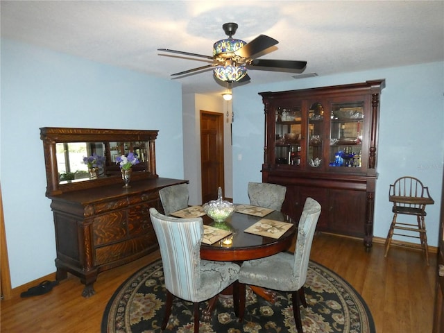 dining area featuring dark wood-type flooring and ceiling fan