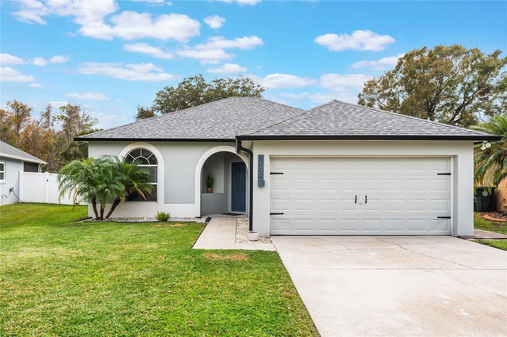 ranch-style house featuring a front yard and a garage