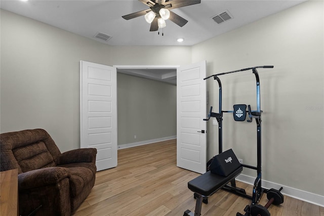 workout room featuring light hardwood / wood-style floors and ceiling fan