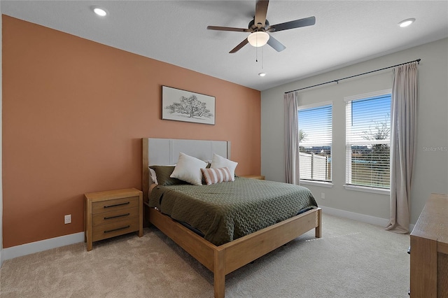 bedroom with light carpet, ceiling fan, and a water view