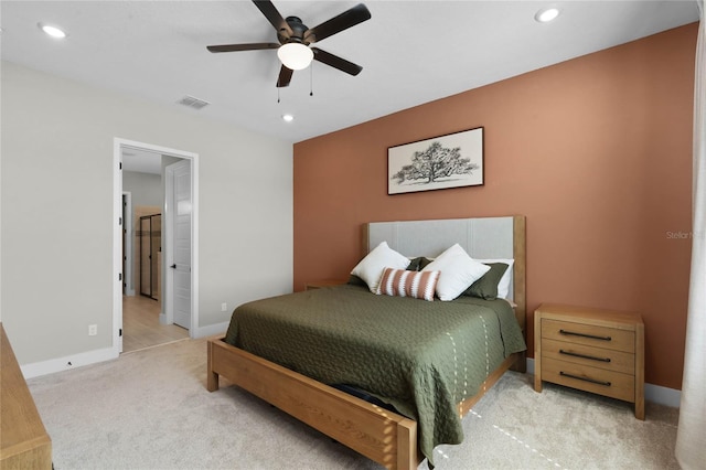 carpeted bedroom with connected bathroom and ceiling fan