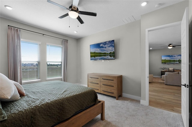 bedroom with ceiling fan and light colored carpet