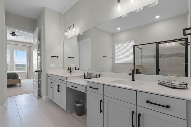 bathroom with tile patterned flooring, vanity, an enclosed shower, and ceiling fan