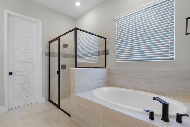 bathroom featuring independent shower and bath and a wealth of natural light