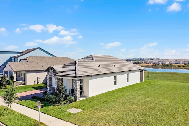 view of property exterior with a yard and a water view