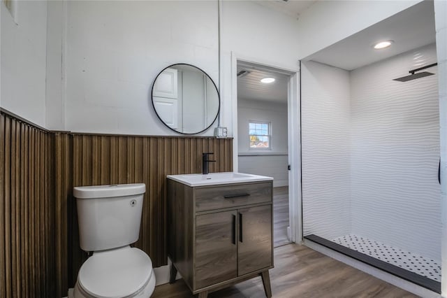 bathroom featuring hardwood / wood-style floors, a shower, vanity, and toilet