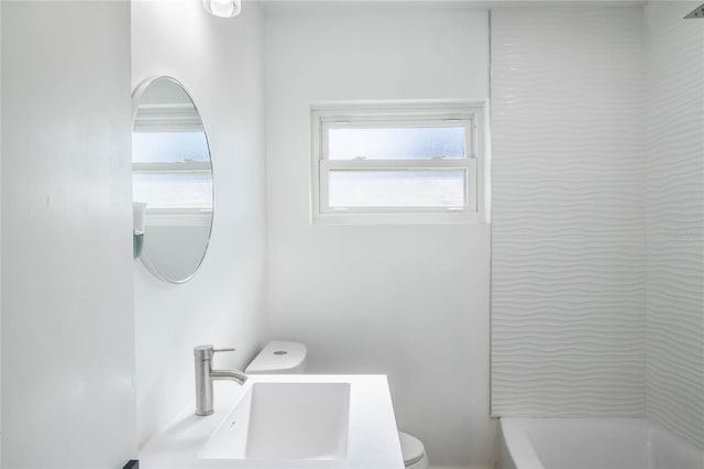 full bathroom with toilet, tub / shower combination, a healthy amount of sunlight, and sink