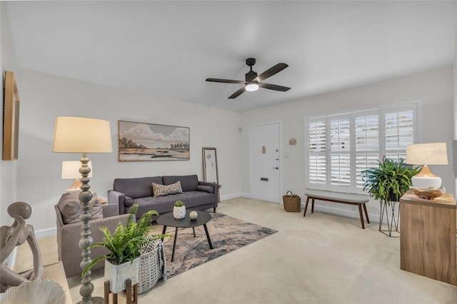 carpeted living area featuring a ceiling fan and baseboards