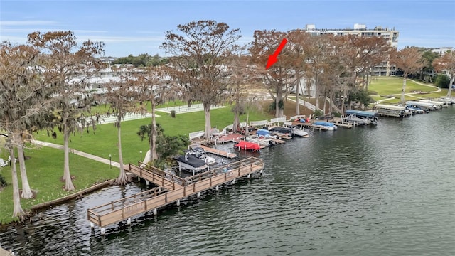 dock area with a lawn, boat lift, and a water view