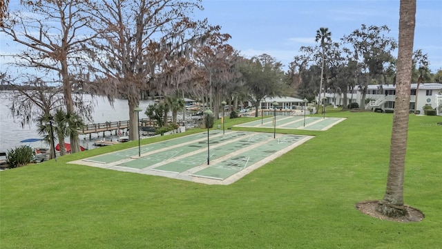 view of property's community featuring shuffleboard, a lawn, and a water view