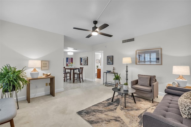 living room with baseboards, visible vents, and ceiling fan