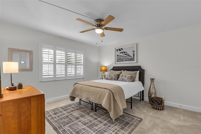 bedroom featuring baseboards, ceiling fan, and light colored carpet