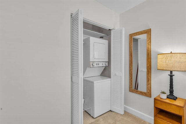 laundry room featuring laundry area, stacked washer / dryer, and baseboards