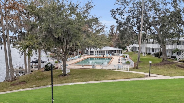 view of community with a pool, a yard, a patio, and fence