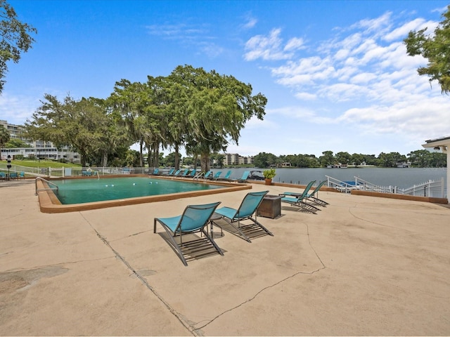 view of pool with a water view and a patio area