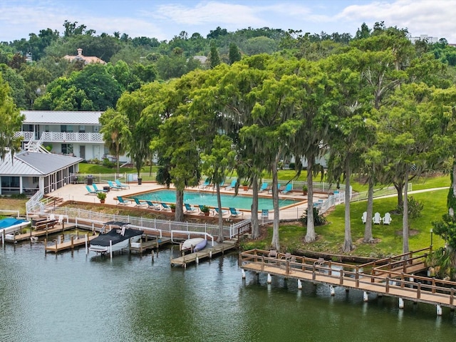 view of dock featuring a water view, fence, and a community pool