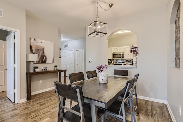 dining area with light hardwood / wood-style flooring and a chandelier