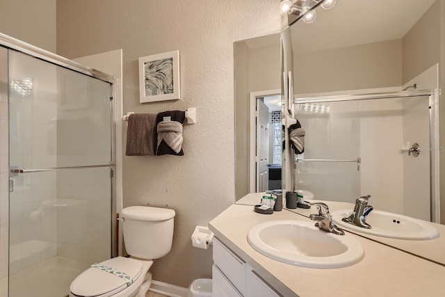 bathroom featuring an enclosed shower, vanity, and toilet