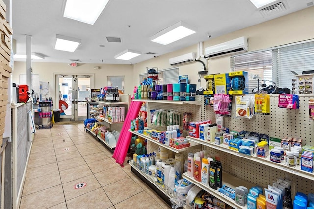 miscellaneous room with light tile patterned flooring, a wealth of natural light, and a wall mounted AC