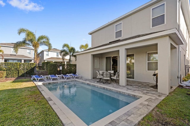 back of house with a fenced in pool, a yard, and a patio area