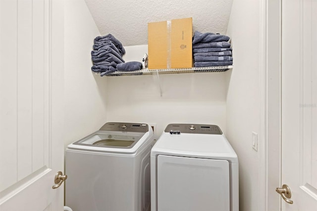 washroom with washer and dryer and a textured ceiling